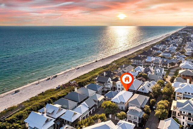 aerial view at dusk with a beach view and a water view