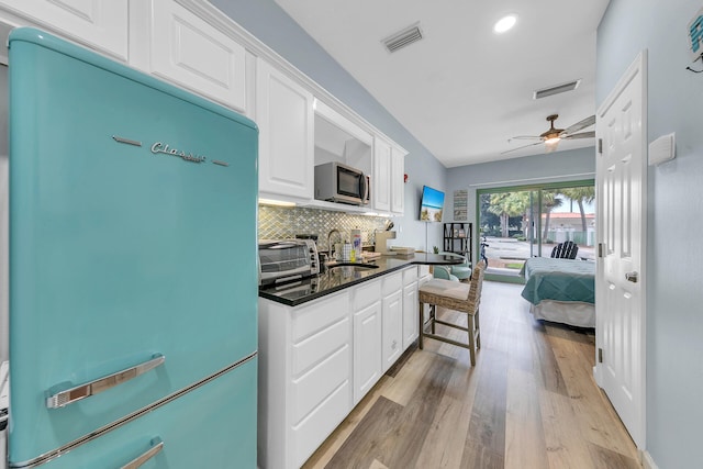 kitchen featuring backsplash, sink, fridge, ceiling fan, and light wood-type flooring