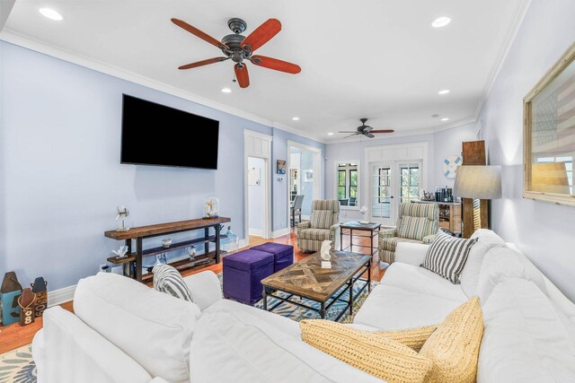 living room featuring hardwood / wood-style floors, ceiling fan, and crown molding