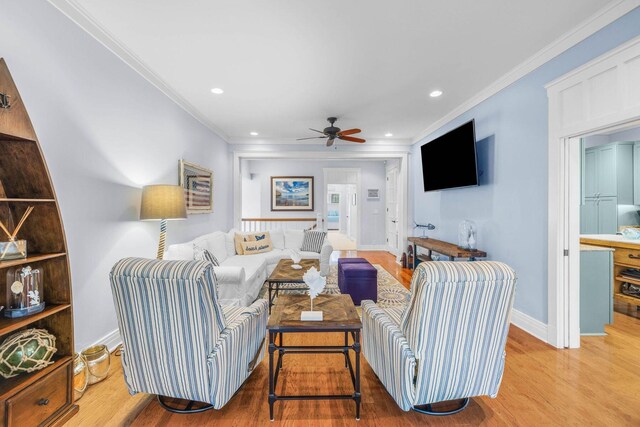 living room featuring ceiling fan, light hardwood / wood-style floors, and ornamental molding