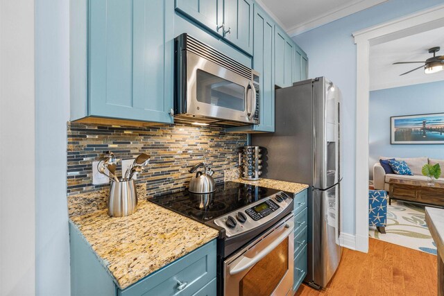 kitchen with blue cabinetry, appliances with stainless steel finishes, and tasteful backsplash