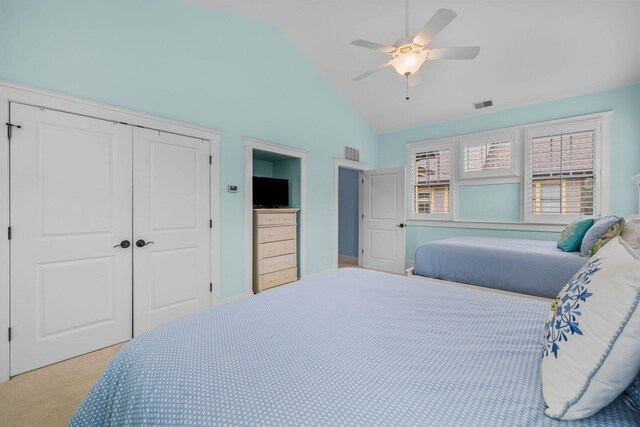 bedroom with a closet, vaulted ceiling, ceiling fan, and light colored carpet