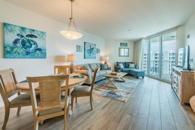 dining space with a wall of windows and light hardwood / wood-style floors