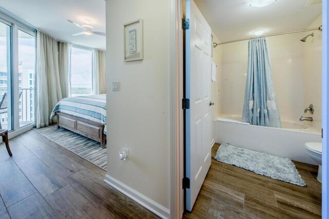 bathroom featuring plenty of natural light, shower / bath combo with shower curtain, toilet, and hardwood / wood-style flooring