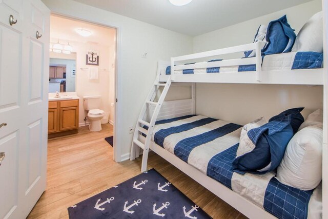 bedroom featuring ensuite bath and light hardwood / wood-style floors