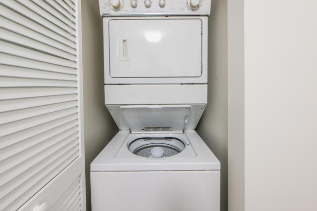 clothes washing area featuring stacked washer and dryer