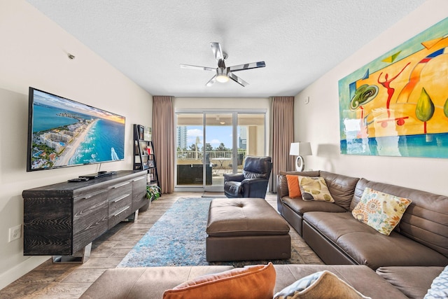 living room with ceiling fan, light hardwood / wood-style floors, and a textured ceiling