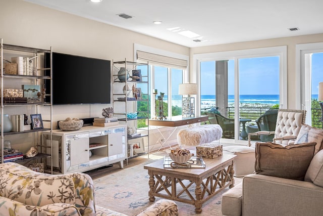 living area with recessed lighting, visible vents, and wood finished floors