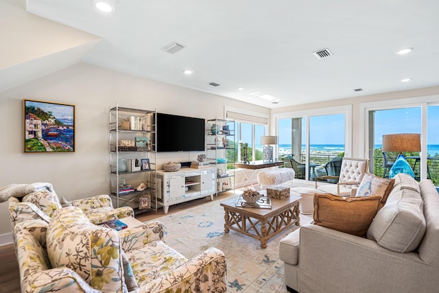 living room featuring vaulted ceiling, visible vents, recessed lighting, and wood finished floors