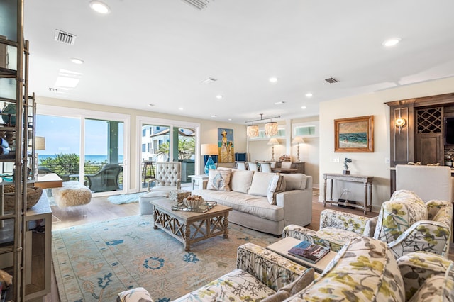 living room with visible vents, recessed lighting, and wood finished floors