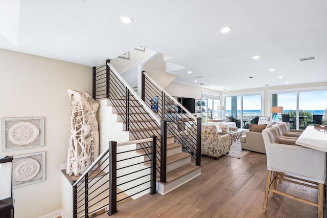 stairway featuring hardwood / wood-style flooring, recessed lighting, and visible vents