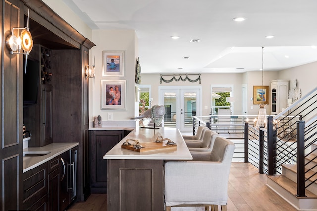 dining area with plenty of natural light, sink, french doors, and light hardwood / wood-style floors