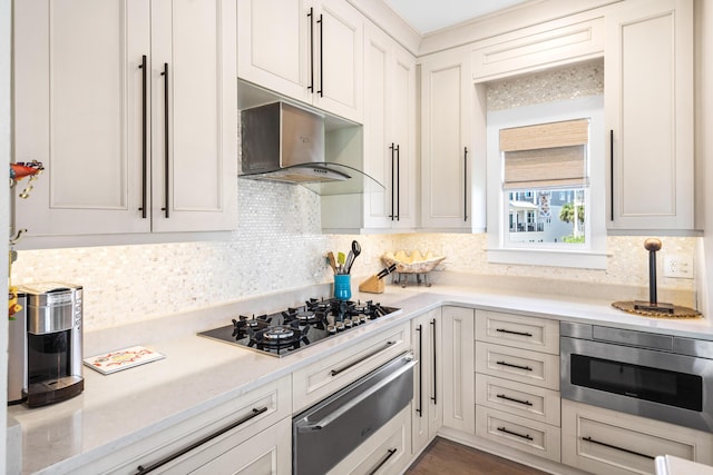 kitchen with stainless steel microwave, backsplash, extractor fan, light countertops, and a warming drawer