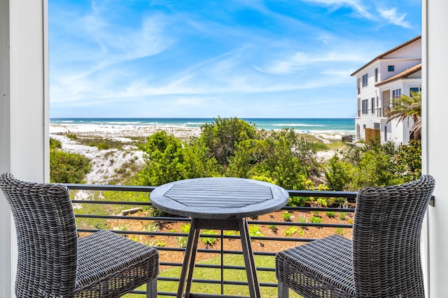 balcony featuring a beach view and a water view