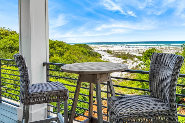 balcony featuring a view of the beach and a water view