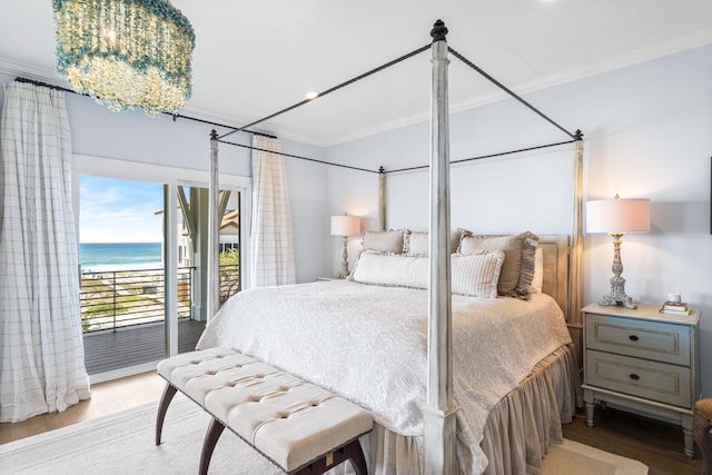 bedroom with access to exterior, wood finished floors, a water view, and ornamental molding
