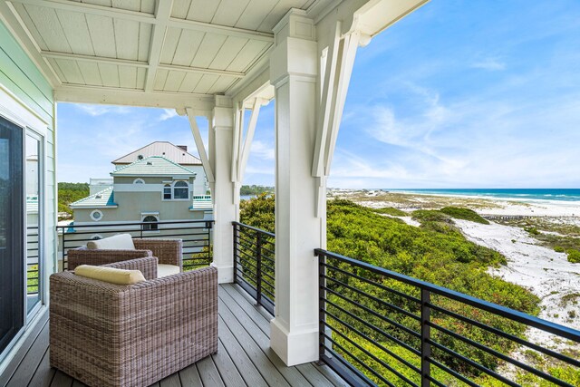 balcony featuring a view of the beach and a water view