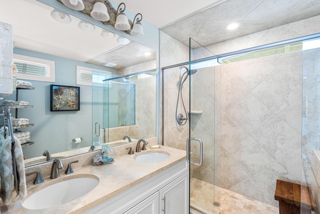 bathroom with double vanity, a stall shower, and a sink