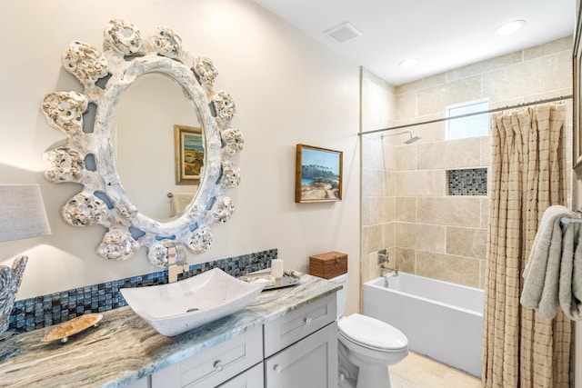 bathroom featuring visible vents, shower / bathtub combination with curtain, toilet, and vanity