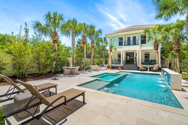 view of swimming pool with pool water feature and a patio