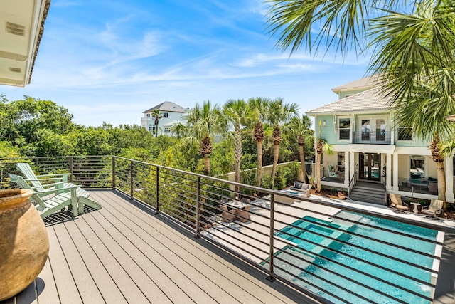 deck with a fenced in pool, a patio, and french doors