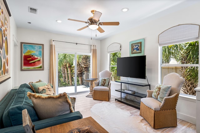 living room featuring plenty of natural light, ceiling fan, and light hardwood / wood-style flooring