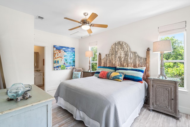 bedroom featuring visible vents, light wood-style flooring, connected bathroom, baseboards, and ceiling fan
