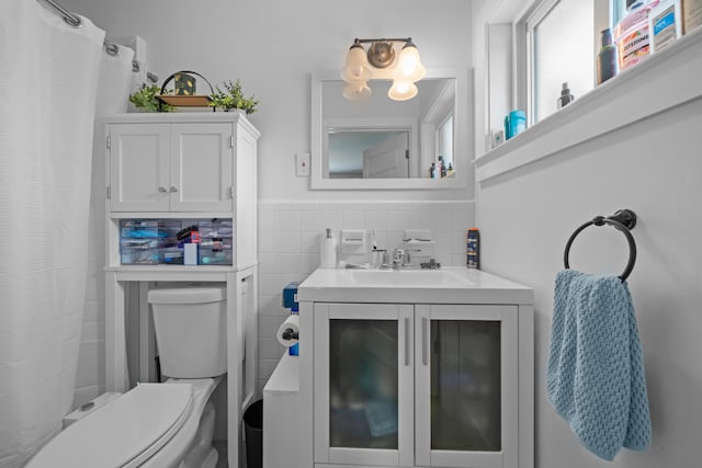 bathroom with curtained shower, toilet, tile walls, tasteful backsplash, and vanity