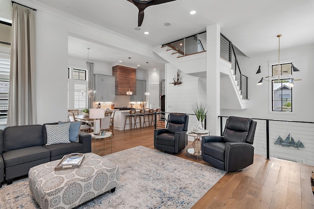 living room with ceiling fan, light hardwood / wood-style floors, and ornamental molding