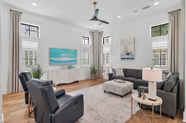 living room featuring ceiling fan, a wealth of natural light, and light hardwood / wood-style flooring