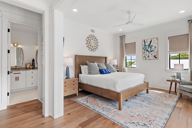 bedroom with ornamental molding, light hardwood / wood-style flooring, ensuite bathroom, and ceiling fan