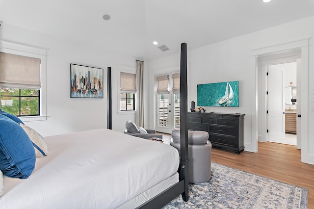 bedroom featuring ensuite bath and hardwood / wood-style floors