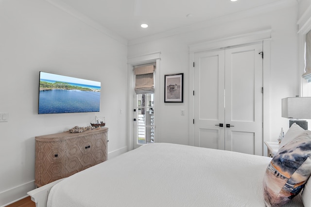 bedroom with ornamental molding, hardwood / wood-style flooring, and a closet