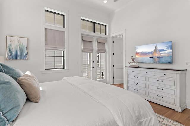 bedroom with light wood-type flooring, multiple windows, access to outside, and french doors