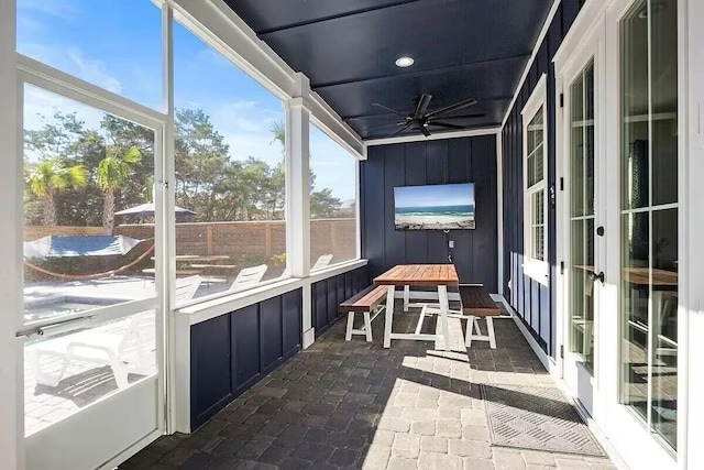 unfurnished sunroom with ceiling fan