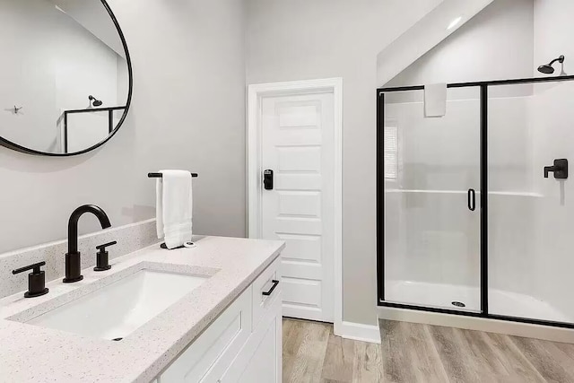 bathroom with a shower with door, vanity, and wood-type flooring