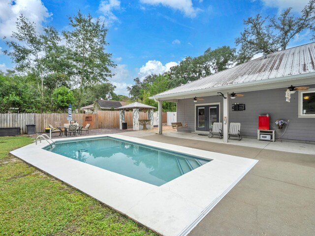 view of swimming pool featuring ceiling fan and a patio area