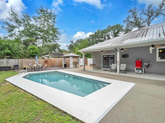 view of swimming pool with a fenced in pool, ceiling fan, french doors, a fenced backyard, and a patio area