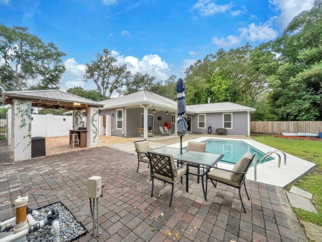 exterior space with a ceiling fan, fence, metal roof, a fenced in pool, and a patio area