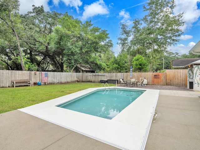 view of swimming pool featuring a patio, a lawn, and a fenced backyard