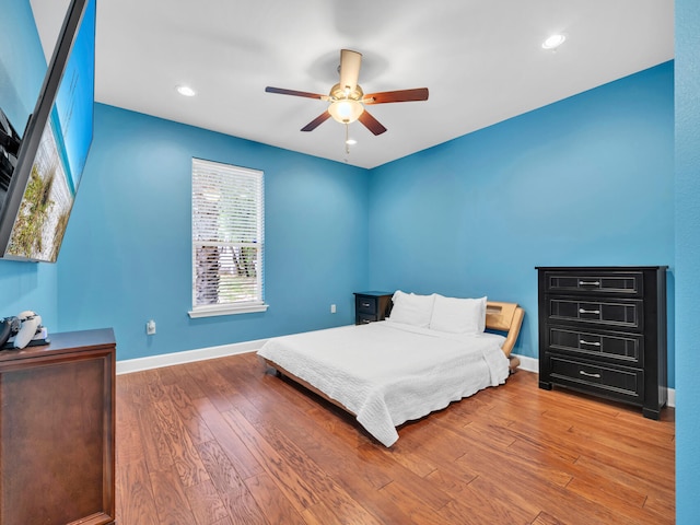 bedroom featuring a ceiling fan, recessed lighting, wood finished floors, and baseboards