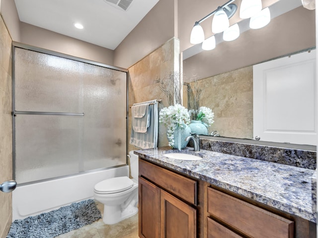 full bathroom featuring tile patterned flooring, vanity, toilet, and bath / shower combo with glass door