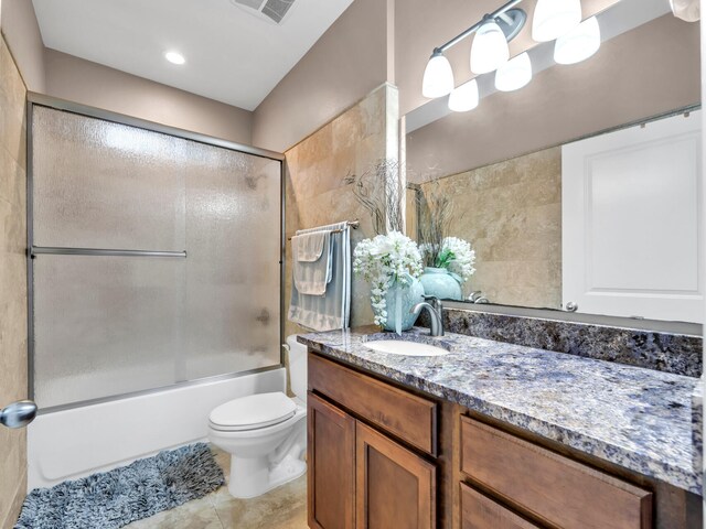 bathroom with visible vents, bath / shower combo with glass door, toilet, tile patterned floors, and vanity