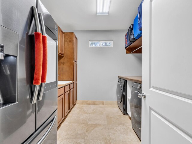 clothes washing area featuring baseboards, independent washer and dryer, and laundry area