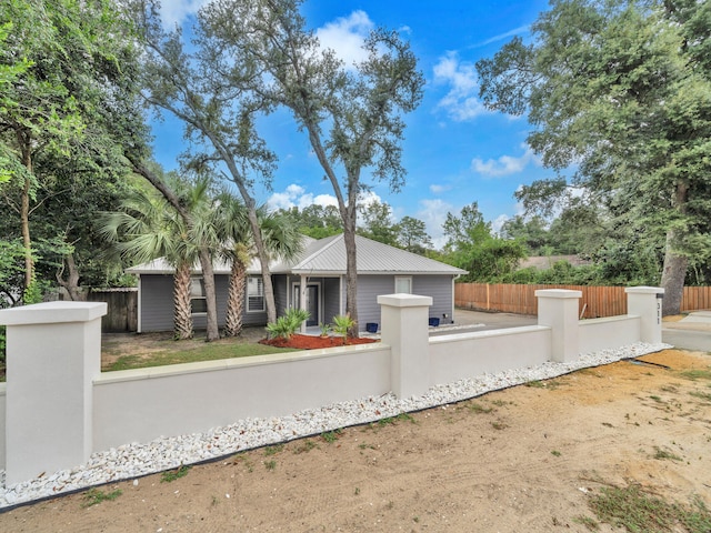 view of front of home with a fenced front yard and metal roof