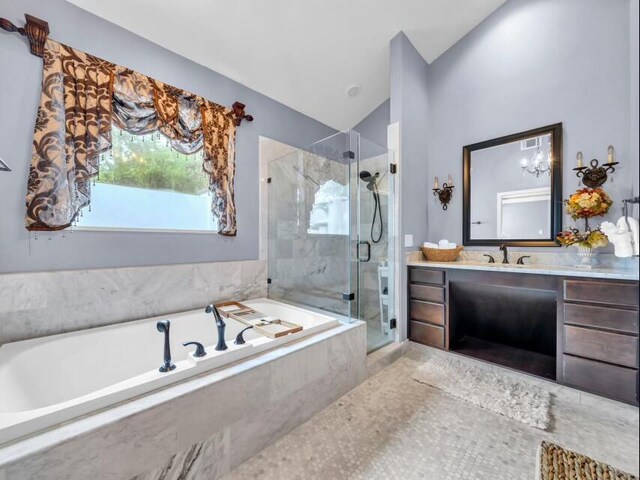 full bath with a bath, a stall shower, vanity, and vaulted ceiling