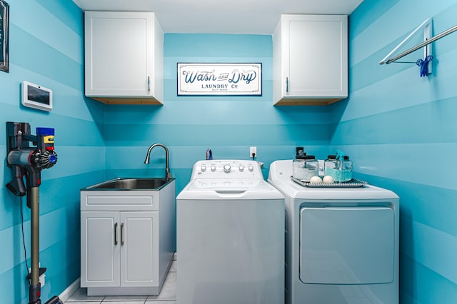 laundry room with washer and clothes dryer, sink, and cabinets