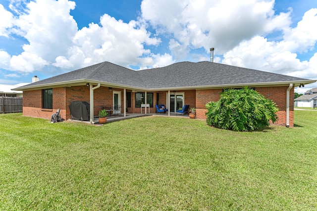 rear view of house featuring a lawn and a patio area