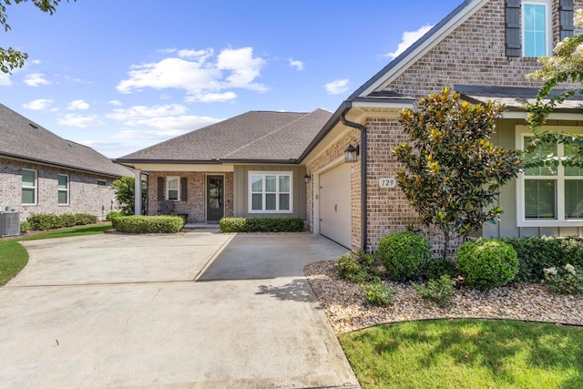 view of front of property featuring a garage and central AC unit