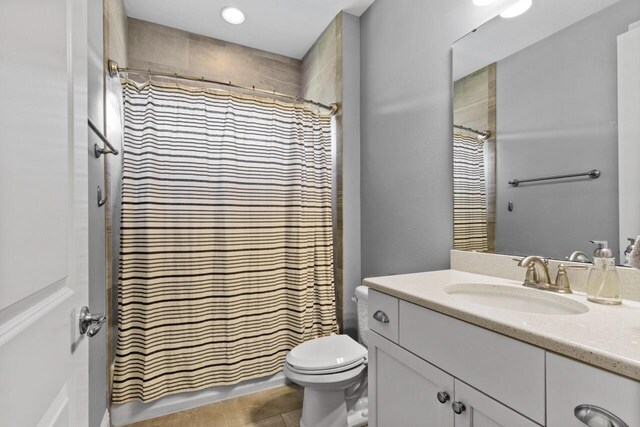 bathroom featuring a shower with shower curtain, tile patterned flooring, toilet, and vanity